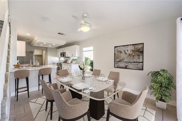 dining space with light tile patterned flooring, ceiling fan, and sink