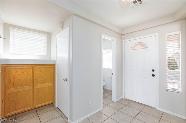 entryway with light tile patterned floors and a wealth of natural light