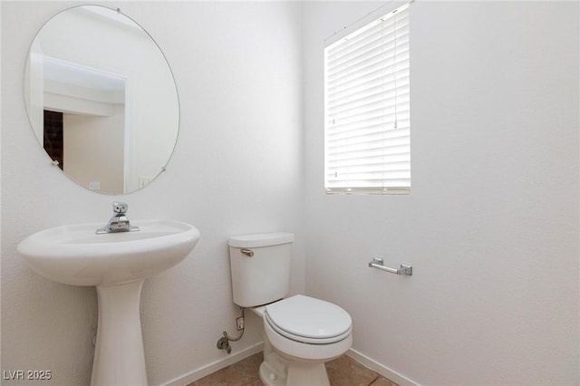 bathroom with tile patterned floors, toilet, and a wealth of natural light