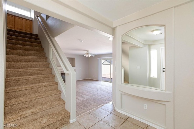 stairs with ceiling fan and carpet floors