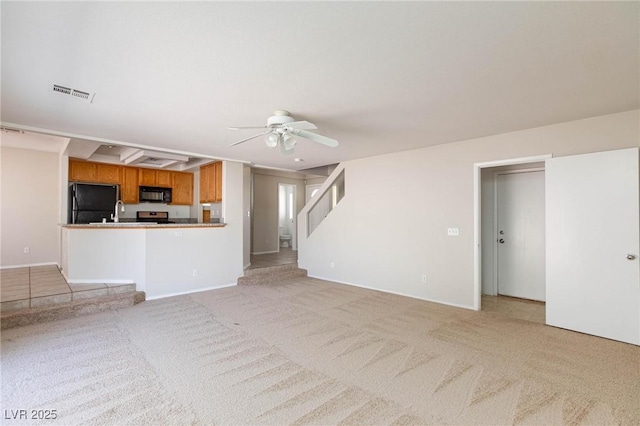 unfurnished living room with ceiling fan and light colored carpet