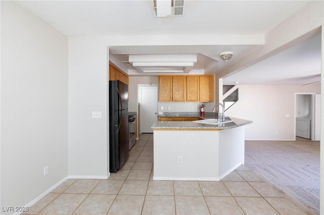 kitchen with kitchen peninsula, light carpet, black fridge, sink, and stainless steel stove