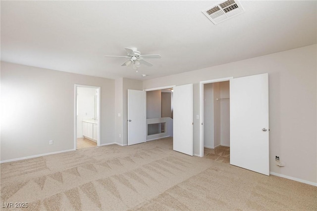 unfurnished bedroom featuring ensuite bath, ceiling fan, a closet, and light carpet