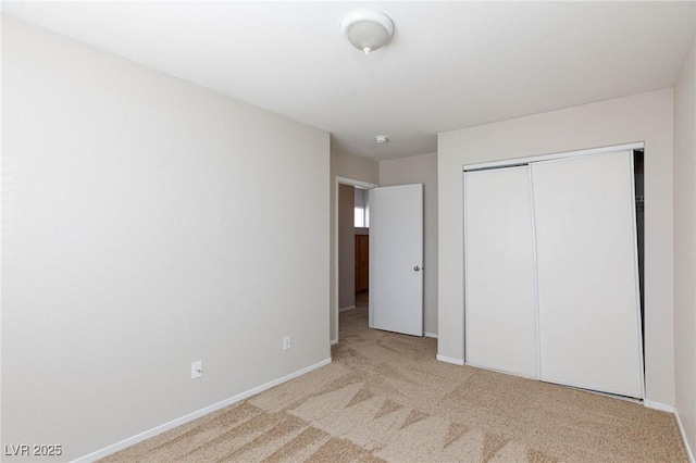 unfurnished bedroom featuring light carpet and a closet