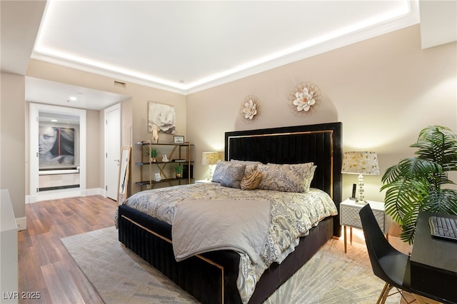 bedroom with hardwood / wood-style floors and ornamental molding