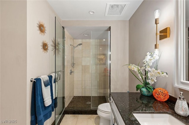 bathroom featuring toilet, vanity, tile patterned floors, and an enclosed shower