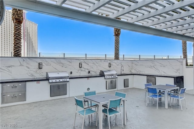 view of patio / terrace with an outdoor kitchen, grilling area, a pergola, and sink