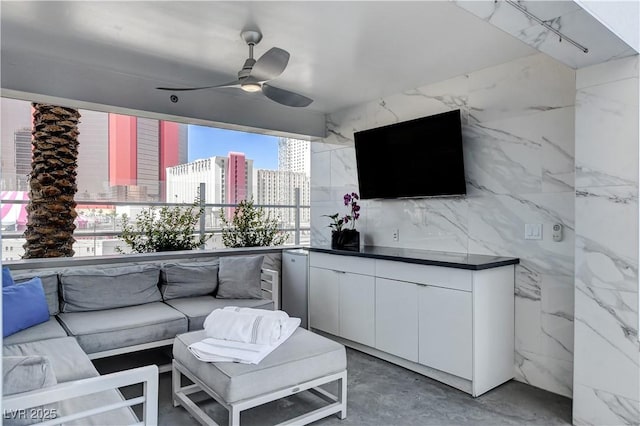 living room featuring ceiling fan and concrete floors