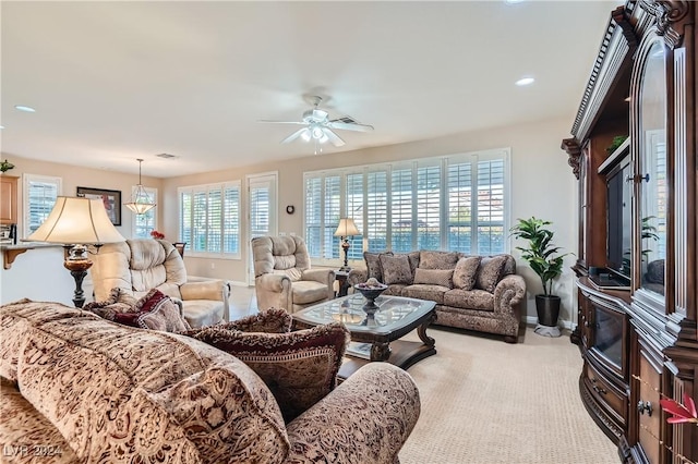 carpeted living room with ceiling fan and plenty of natural light