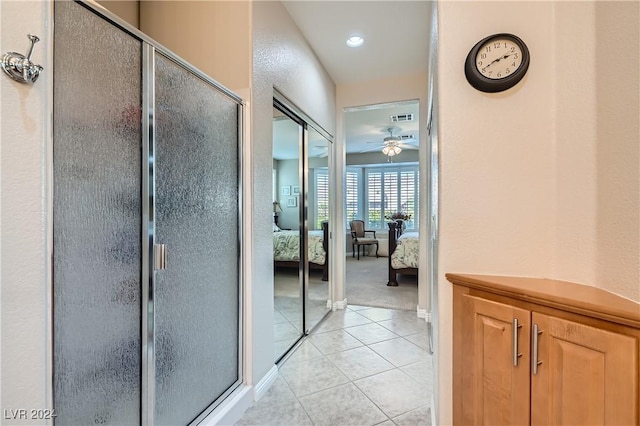 bathroom featuring ceiling fan, walk in shower, and tile patterned floors