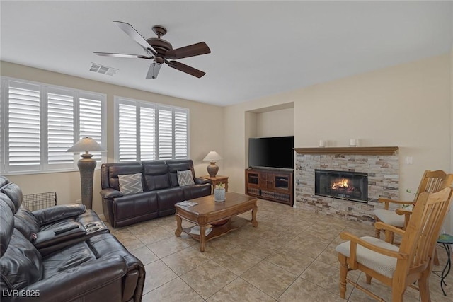 living room featuring ceiling fan, light tile patterned floors, and a fireplace