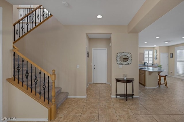 foyer entrance with sink and light tile patterned flooring