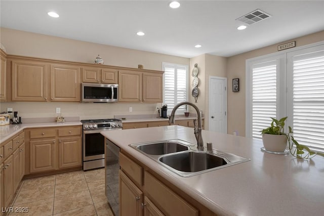 kitchen with sink, stainless steel appliances, and light brown cabinetry