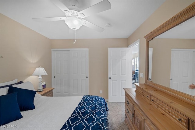 carpeted bedroom with ceiling fan and a closet