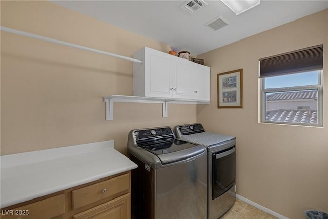 laundry room featuring cabinets, light tile patterned floors, and washing machine and dryer