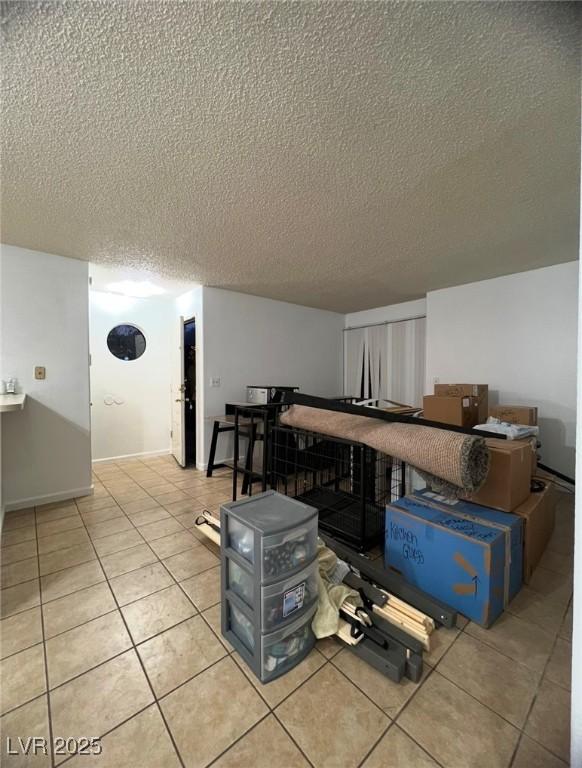 interior space featuring light tile patterned flooring and a textured ceiling