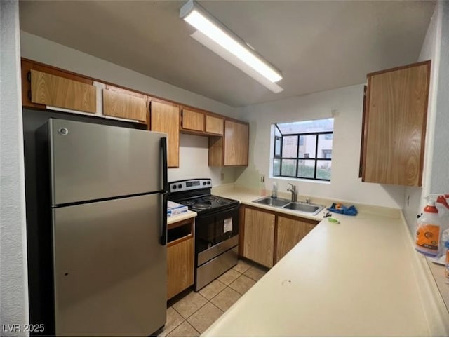 kitchen featuring stainless steel refrigerator, sink, light tile patterned floors, and electric range oven