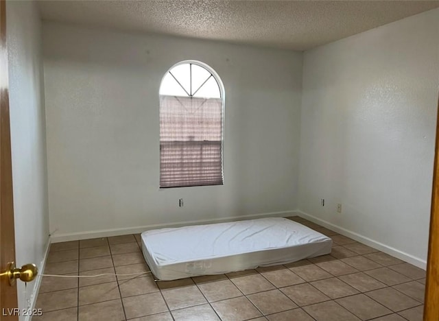 unfurnished bedroom featuring light tile patterned floors and a textured ceiling