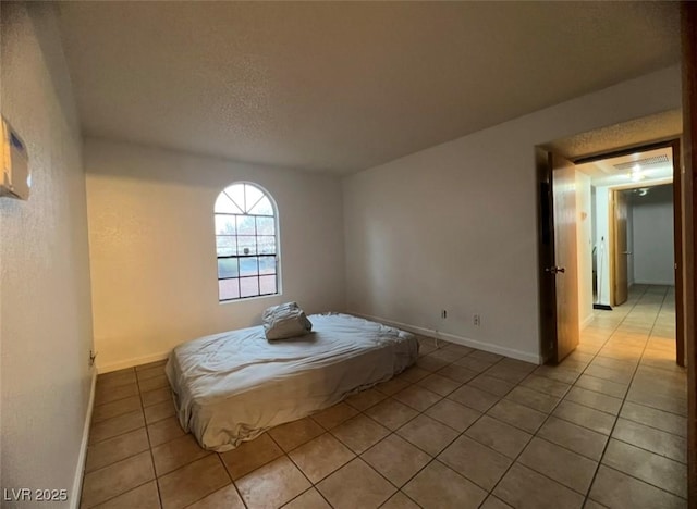 bedroom with light tile patterned floors and a textured ceiling