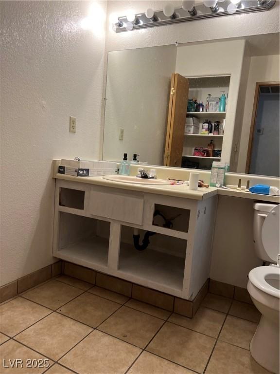 bathroom featuring toilet, tile patterned floors, and sink