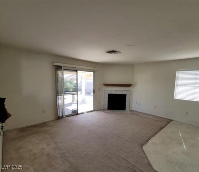 unfurnished living room with carpet and a fireplace