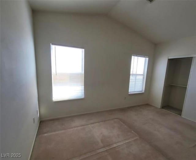 unfurnished bedroom with light colored carpet and vaulted ceiling