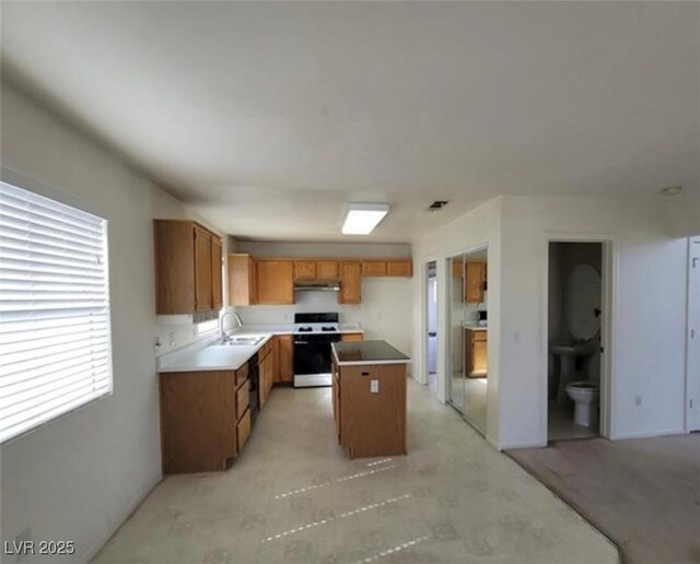 kitchen with white range, a center island, a wealth of natural light, and sink