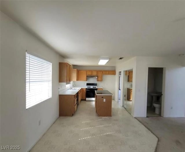 kitchen featuring sink, a kitchen island, and white stove