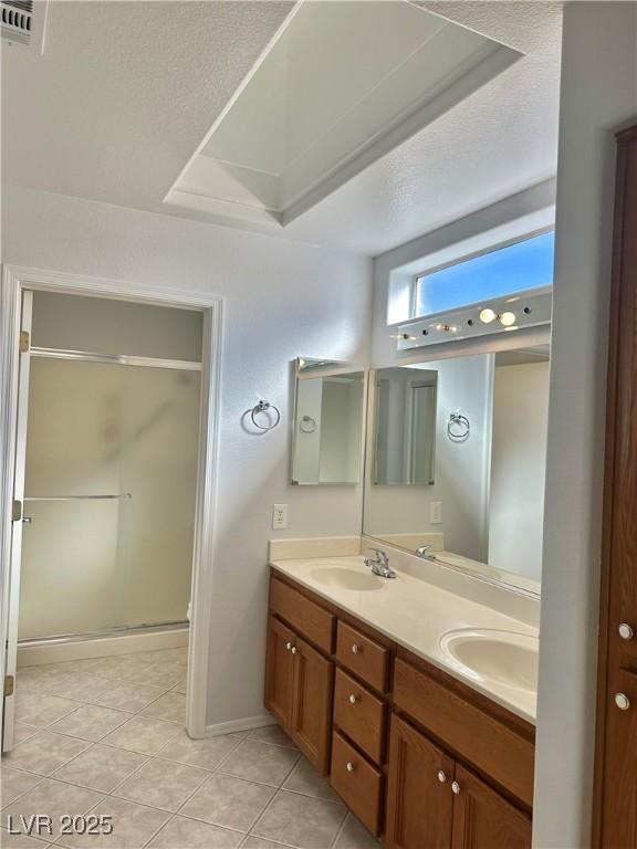 bathroom with vanity, tile patterned floors, and a shower with shower door