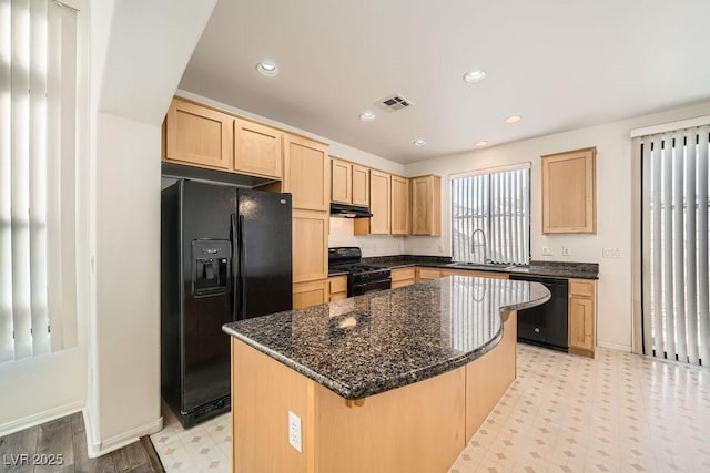 kitchen featuring a center island, light brown cabinets, black appliances, sink, and dark stone countertops