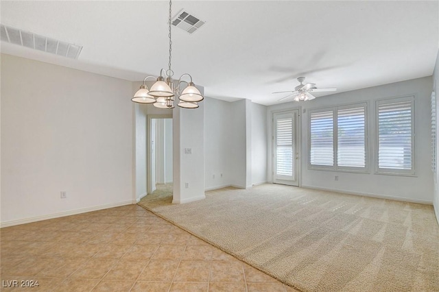 empty room with light tile patterned floors and ceiling fan with notable chandelier