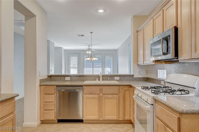 kitchen featuring light stone counters, stainless steel appliances, ceiling fan, sink, and light brown cabinets