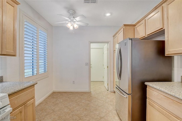 kitchen with stainless steel fridge, light brown cabinetry, ceiling fan, and plenty of natural light