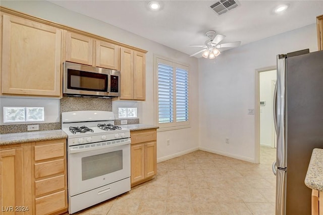 kitchen with ceiling fan, light brown cabinetry, and appliances with stainless steel finishes