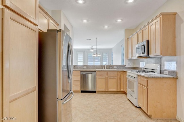 kitchen featuring light brown cabinetry, stainless steel appliances, sink, a notable chandelier, and hanging light fixtures