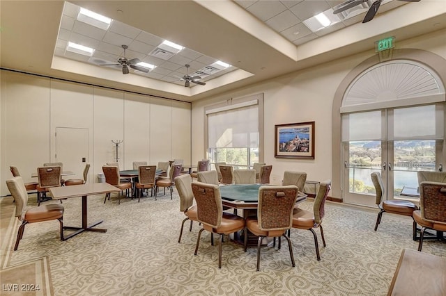 dining room with a paneled ceiling, ceiling fan, a raised ceiling, and a high ceiling