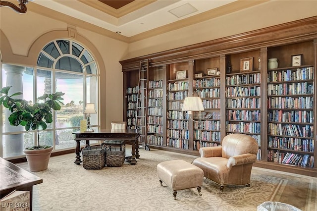 living area with a high ceiling and ornamental molding