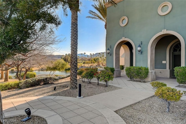 view of exterior entry with a water and mountain view