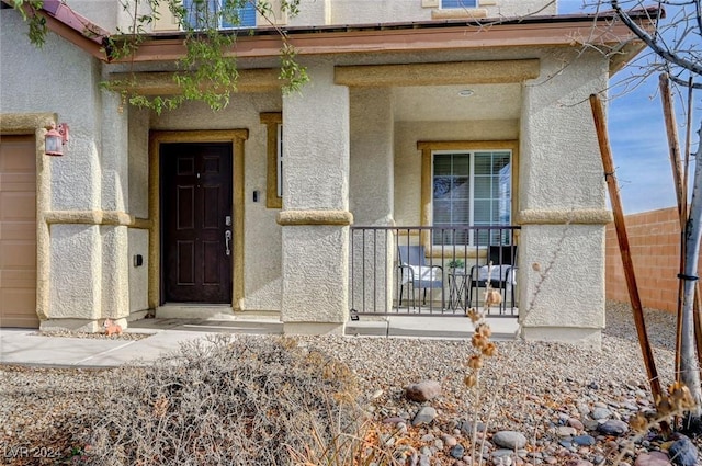 view of exterior entry featuring covered porch