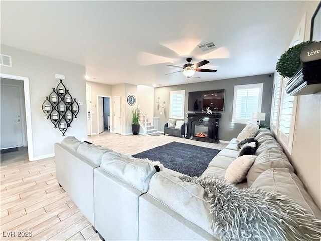 living room featuring ceiling fan and light hardwood / wood-style floors