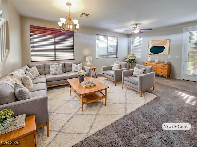 living room with carpet flooring and ceiling fan with notable chandelier