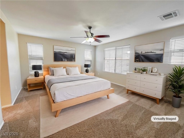 bedroom with multiple windows, ceiling fan, and light colored carpet