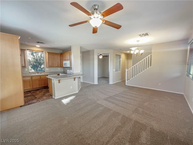 kitchen with a center island, hanging light fixtures, stove, a breakfast bar, and carpet