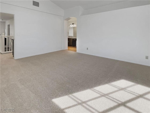 empty room with carpet floors and vaulted ceiling