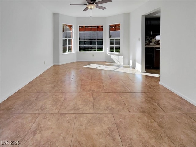 tiled spare room with ceiling fan