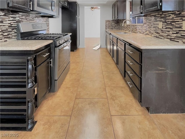 kitchen with appliances with stainless steel finishes, backsplash, ceiling fan, sink, and light tile patterned floors