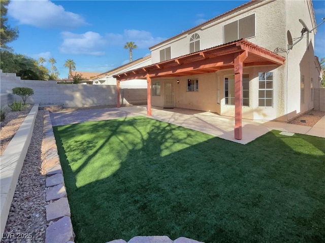 back of house featuring a pergola, a patio area, and a yard