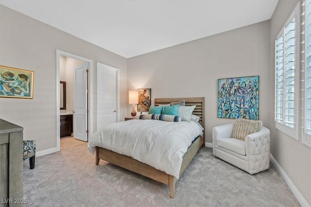 bedroom with ensuite bath and light colored carpet