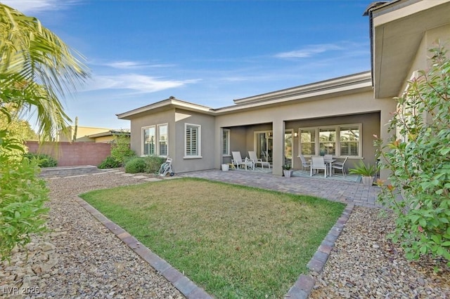 back of property featuring a patio area and a yard