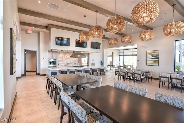 dining space with plenty of natural light, light tile patterned floors, a high ceiling, and an inviting chandelier